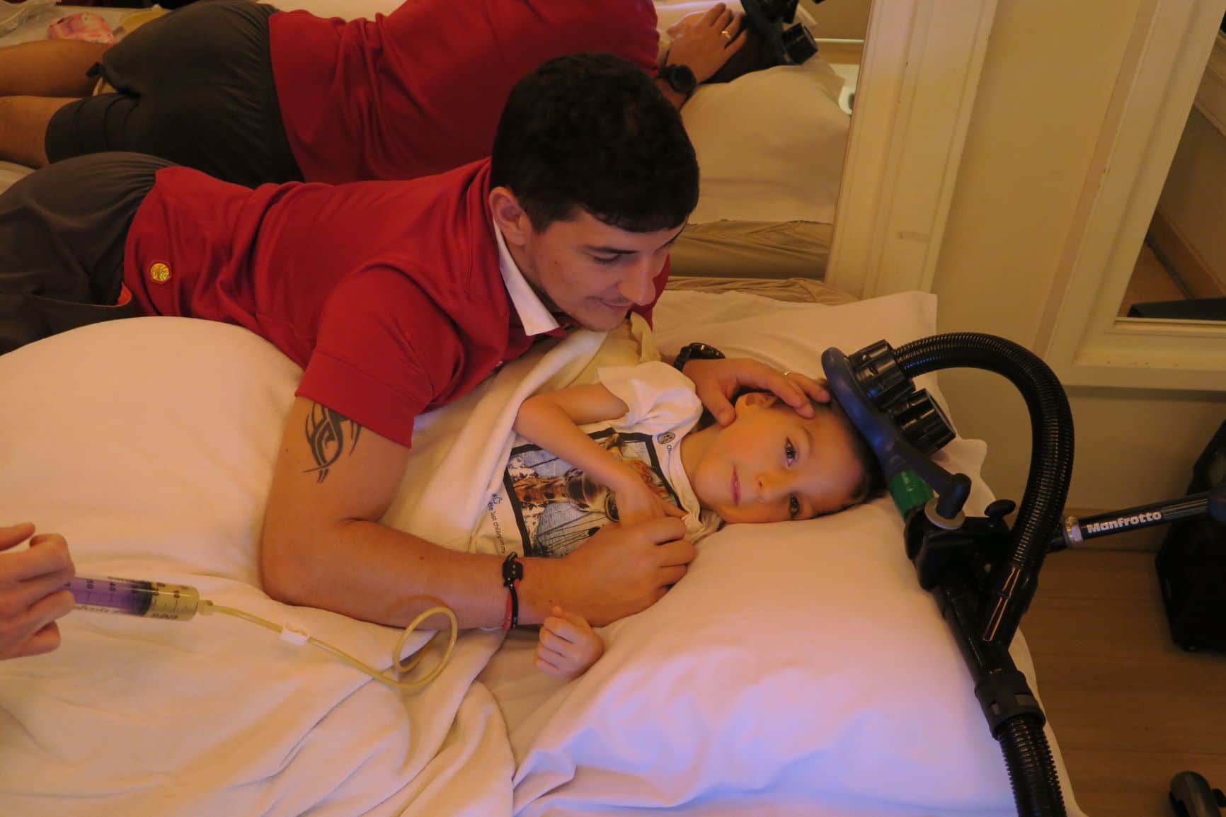 Immagine di Enzo con il padre mentre riceve la terapia magnetica transcranica